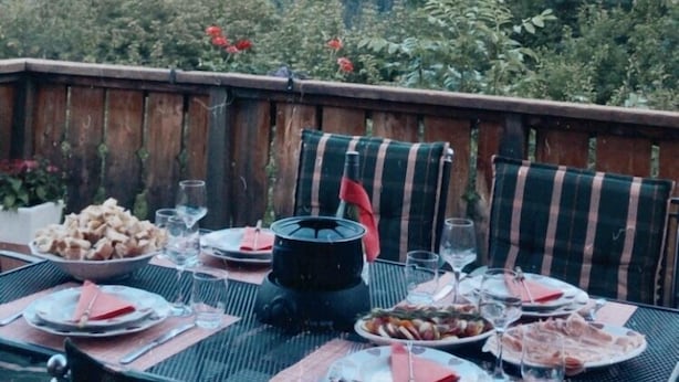 Une table à manger installée à l’extérieur, avec vue sur les montagnes.