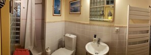Bathtub, hair dryer, towels, toilet paper