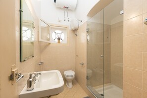 A bathroom with a sink, toilet, and glass-enclosed shower. - Casa Particular Luxury (Palermo)
