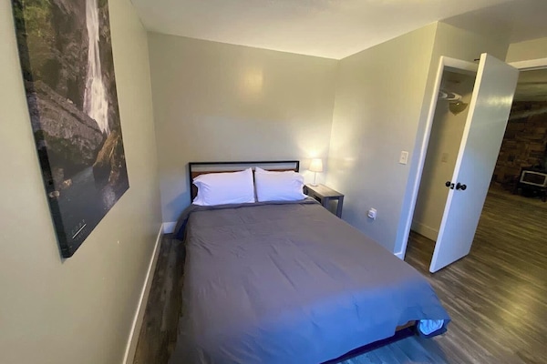 Relax and recharge in this cozy queen bedroom featuring a comfortable bed, soft linens, and a peaceful atmosphere.