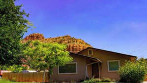 A single-story house with a front yard, a small tree, and a mountain in the background. - Family Home in Kanab w/ private Hot Tub, Near Zion (Kanab)