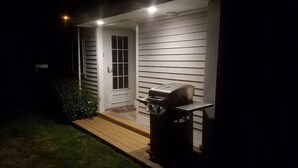 A house with a front porch, a grill, and a door.