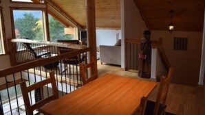 A wooden interior with a dining area, a staircase, and a view of the outdoors. - Elk Ridge (Packwood)