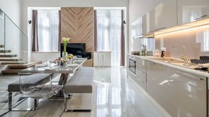 A modern kitchen with a dining area, large windows, and a central island.