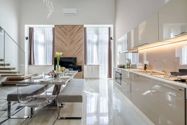 Una cocina moderna con zona de comedor, ventanas amplias y una isla central.