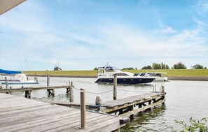 Guests can enjoy serene lakeside views from the dock, where a boat is moored.