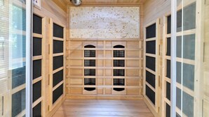 Ein Saunaraum mit Holzwänden, einer gefliesten Decke und einer Bedieneinheit links.