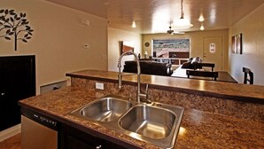 A kitchen with granite countertops, stainless steel sinks, and a dishwasher. - Beautiful Townhome adjacent to the Pool and Hotub (Moab)