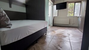 Une chambre à coucher avec un lit, un radiateur et une fenêtre.