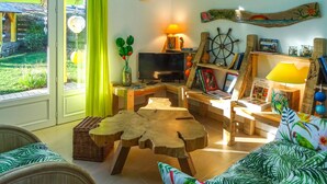 A cozy living room with a television, wooden furniture, a bookshelf, and a view of the outdoors. - 2 bedroom awesome home in Plouguerneau (Plouguerneau)