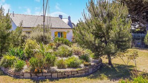 A house with a stone garden bed, a yellow door, and a grey roof. - 2 bedroom awesome home in Plouguerneau (Plouguerneau)