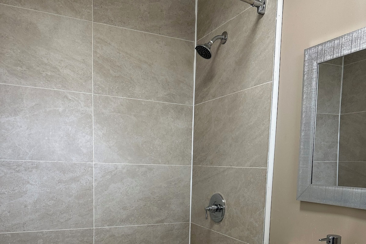A bathroom with a bathtub, a shower, and a sink.