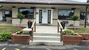 A building with a front entrance, a mailbox, and a sign indicating room numbers. - Champlain Motor Inn (Pembroke)