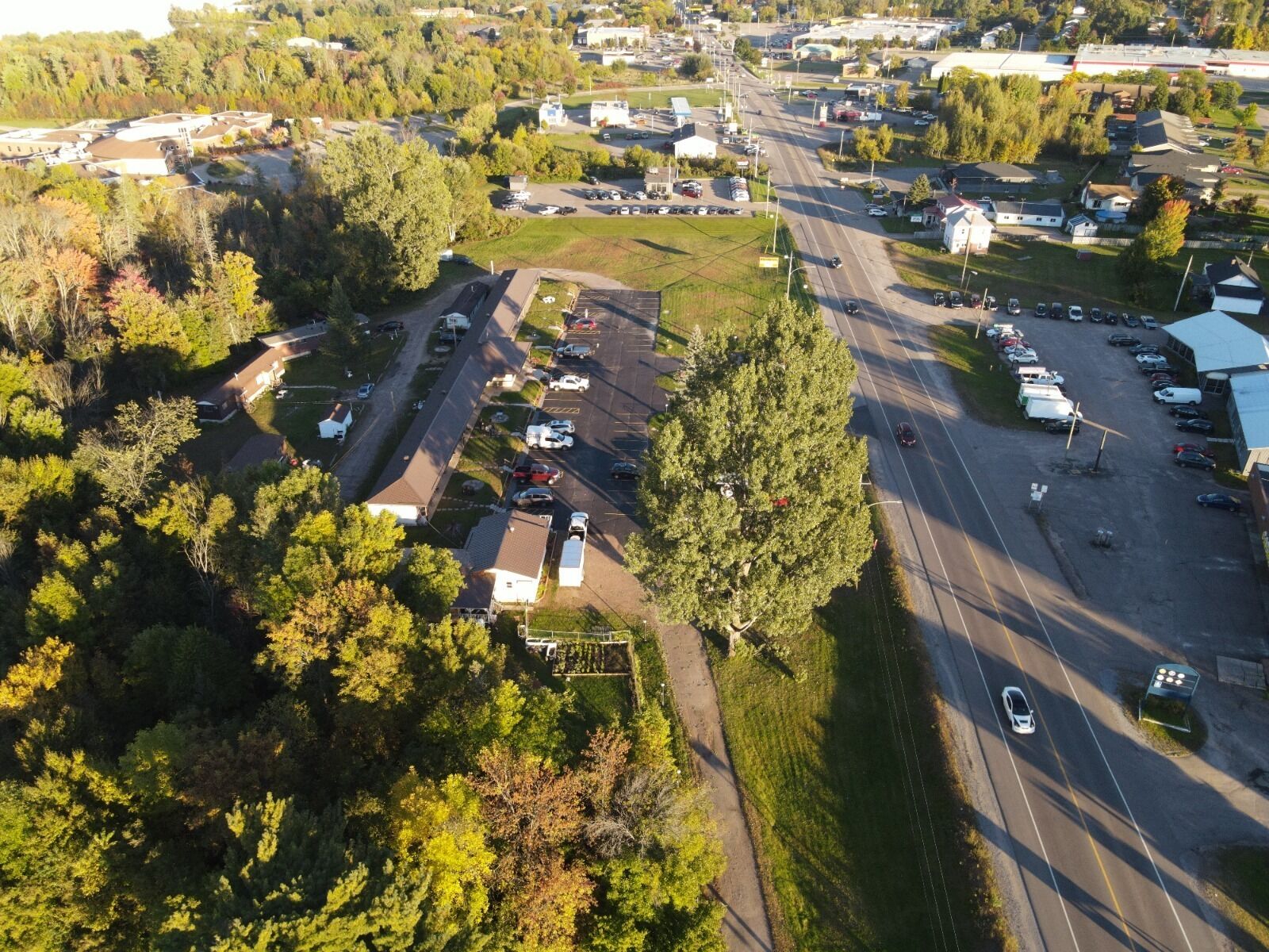 An aerial view of a suburban area with a parking lot, buildings, and roads.