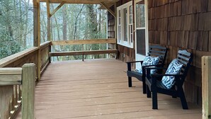 Un pontile in legno con ringhiera, una panchina e un tavolo con sedie.