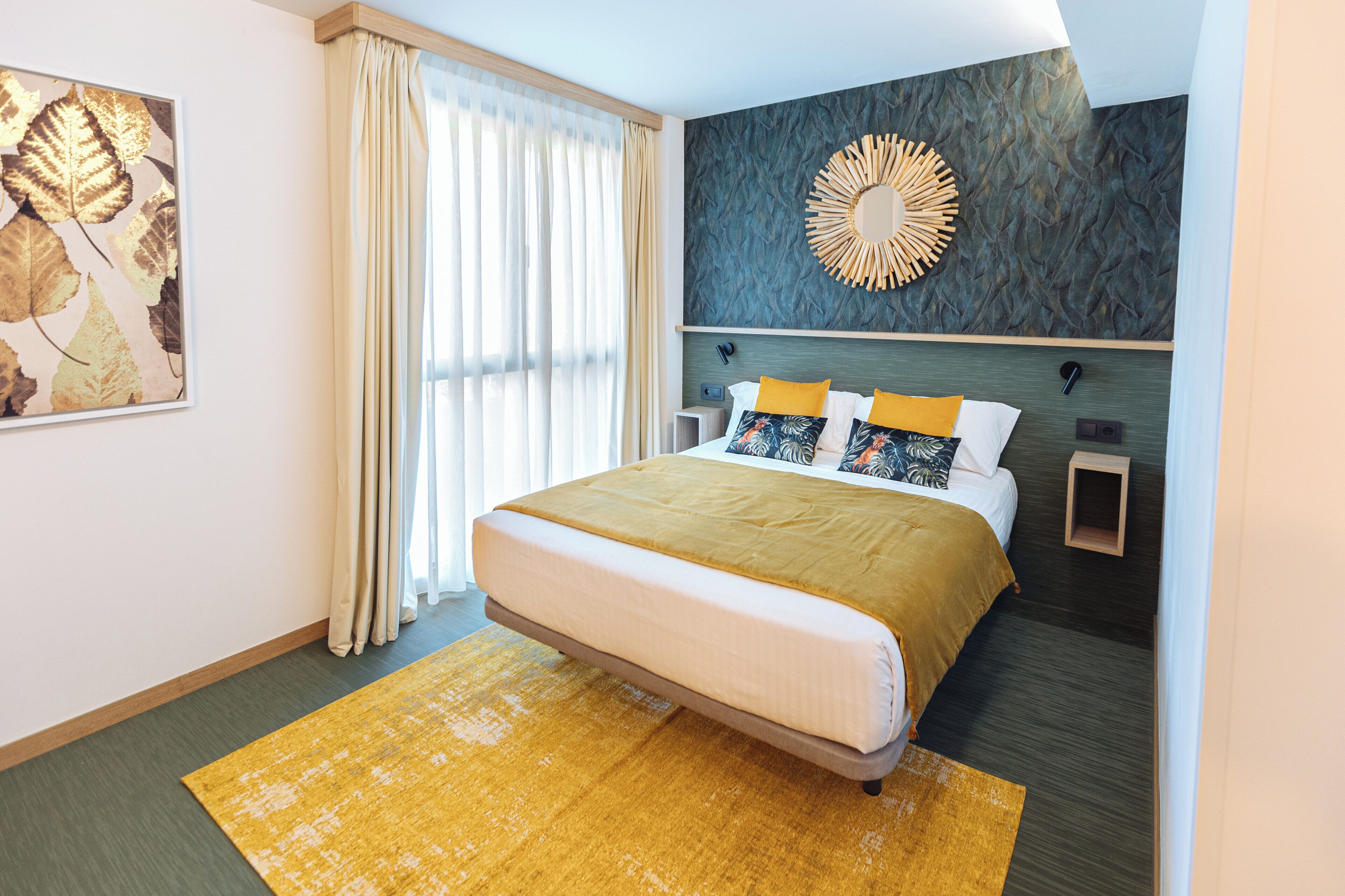 Una habitación de hotel moderna con una cama grande, un adorno en la pared y vistas al exterior.