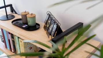 Escritorio de madera con un calendario, un control remoto y una bandeja con dos velas.
