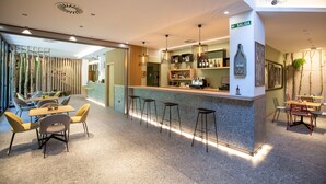 Un área de bar moderna con mostrador, taburetes y un cartel que indica 'SALIDA'.