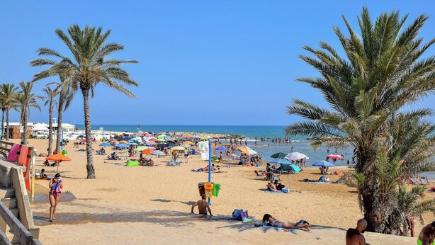 A beach with palm trees, umbrellas, and people. - 3 bedroom pet friendly home in Marina di Modica (Marina di Modica)