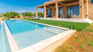 A modern house with a swimming pool, outdoor seating, and a stone facade. - Can Navarro by Interhome (Inca)