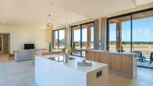 A modern kitchen with a central island, large windows, and a view of the outdoors. - Can Navarro by Interhome (Inca)