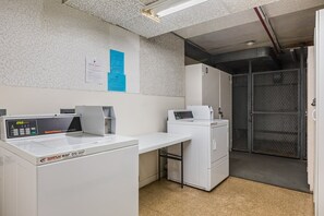 Ein Waschbereich mit einer WASH WAF 372 Maschine, einer Speed Queen Commercial Waschmaschine und einem Metallschrank.