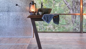 Una mesa de madera con un farol, un cuenco y una toalla.