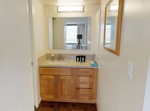 A bathroom with a sink, mirror, and wooden cabinets.