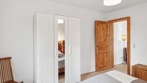 Una stanza con un letto, un armadio in legno e una porta di legno.