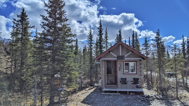 A small cabin with a sign reading "MOOSE" and a "PARKING" sign nearby. - Rustic Moose Cabin Getaway - Glamping (Cantwell)