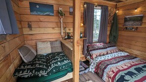A cozy cabin room with two beds, wooden walls, a painting of a mountain night, and a sign reading "Relax Cabin". - Rustic Moose Cabin Getaway - Glamping (Cantwell)