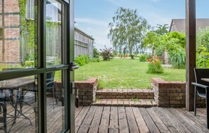 Eine offene Terrasse mit Holzdeck, Backstufen und einem Rasen.