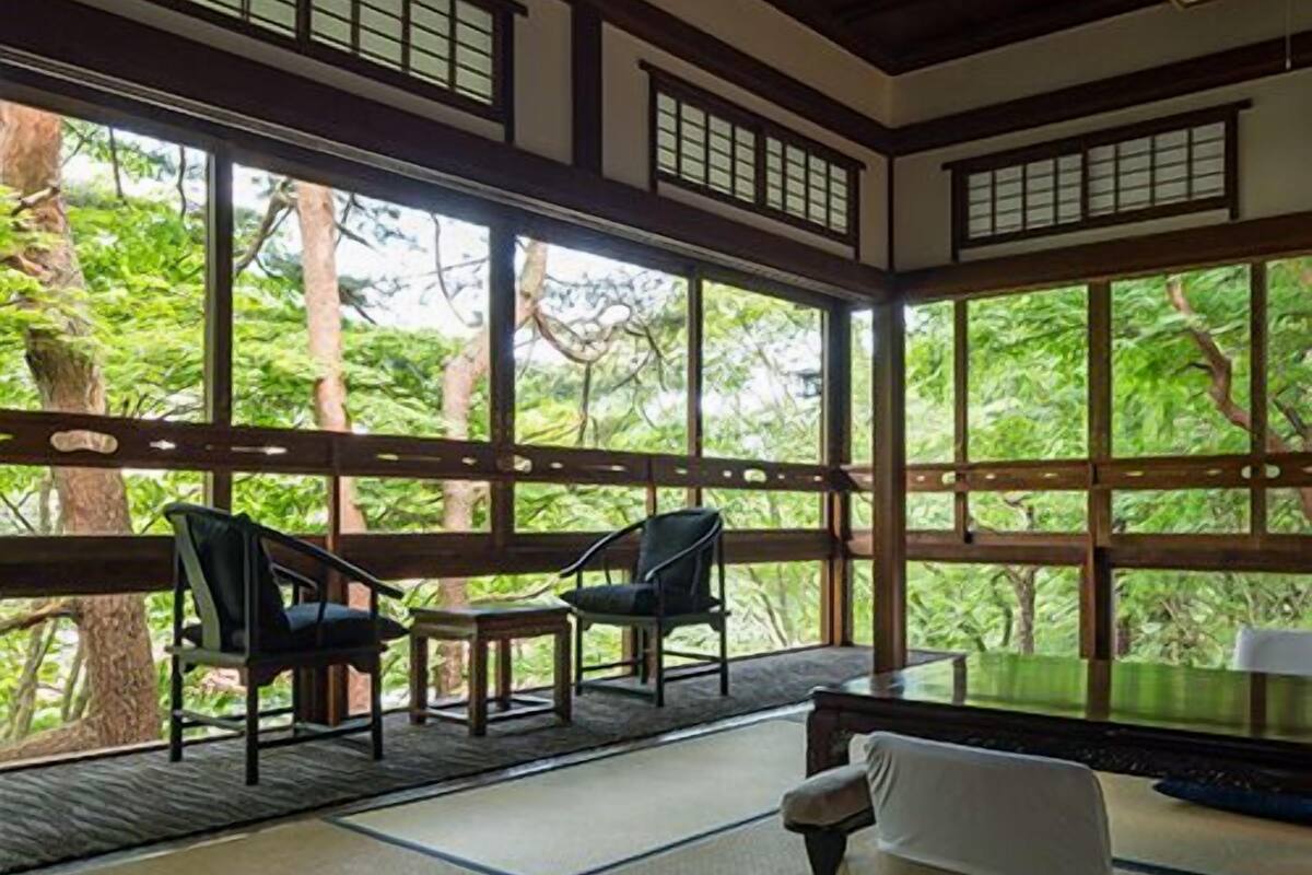 Une pièce de style japonais traditionnel, avec un sol recouvert de tatamis, une table basse et des chaises.