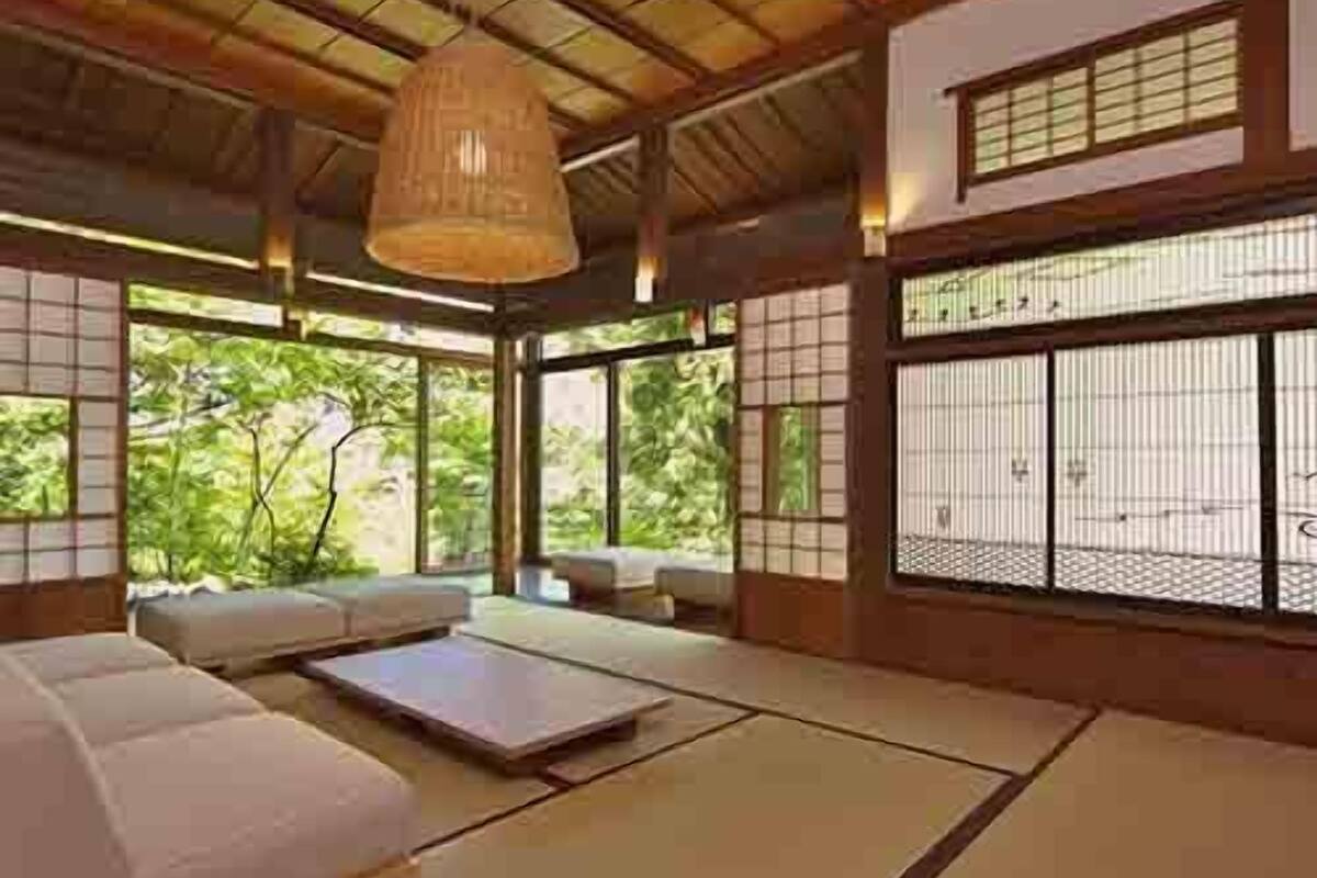 Une pièce de style japonais traditionnel, avec un sol recouvert de tatamis, un plafond bas en bois et des portes coulissantes en papier de riz (shoji).