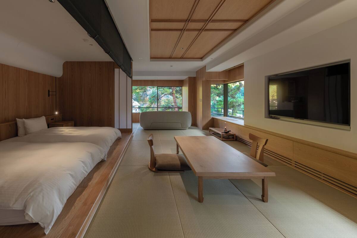 Une chambre d’hôtel moderne équipée d’un grand lit, d’un canapé, d’une table à manger et d’un téléviseur.