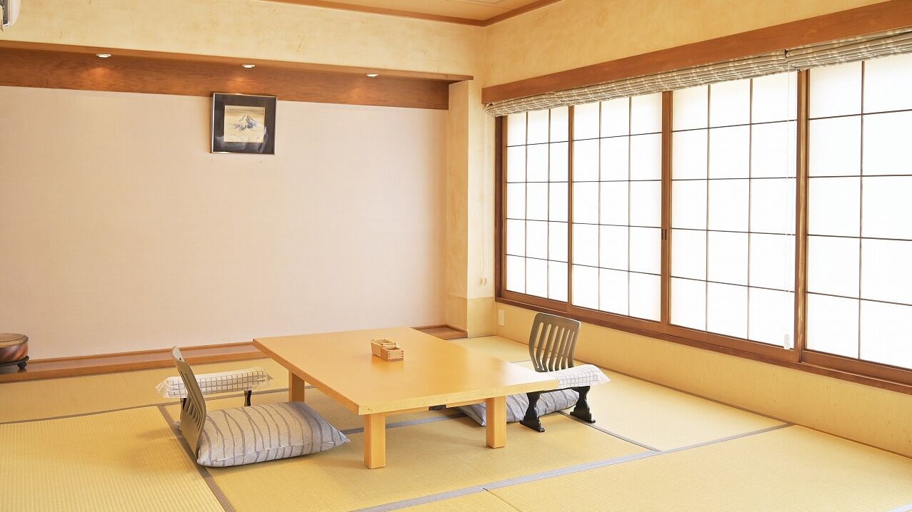 A traditional Japanese room with tatami flooring, a low wooden table, a cushioned bench, and a shoji screen window.