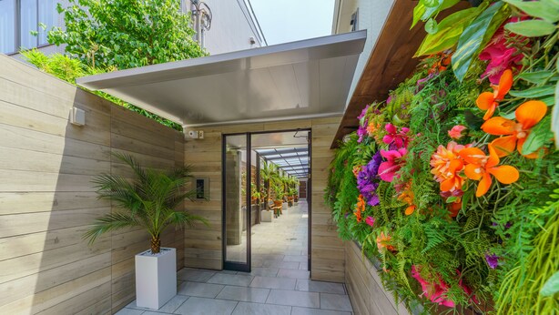 A modern corridor with a wooden wall and a vertical garden. - Orion Resort (Tokyo)