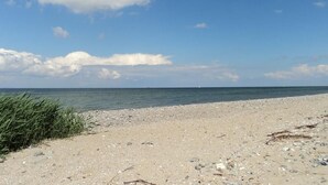 Une plage avec un ciel dégagé et une mer calme.