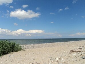 Ein Strand mit blauem Himmel und ruhiger See.