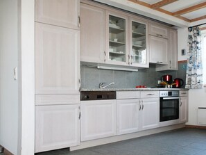A kitchen with white cabinets, a stainless steel oven, and a tiled backsplash.