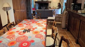 A cozy dining area with a table set for four, wooden chairs, and a patterned tablecloth.
