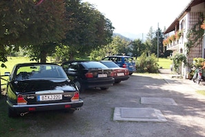 Una hilera de autos estacionados en una entrada de casa con un edificio a la derecha.