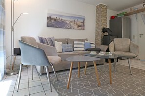 A living room with a sofa, two armchairs, a coffee table, and a painting on the wall. - Urlauberdorf 47a, Deutschland (Ostseebad Boltenhagen)