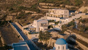 Uma villa moderna com vários níveis, piscina e vista para a paisagem montanhosa ao redor.