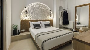 Quarto moderno com uma cama grande, um painel de parede curvo, um espelho e uma mesinha de cabeceira.