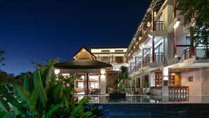 A modern hotel with a pool, multiple floors, and outdoor seating areas. - Nghe Prana Hotel and Spa Hoi An (Da Nang)