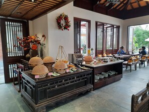 Zona de desayuno tipo buffet con diversas opciones de comida y elementos decorativos.