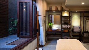A room with a sliding door, a sink, a mirror, a bed, and a small plant. - Nghe Prana Hotel and Spa Hoi An (Da Nang)