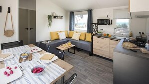 Een moderne woonkamer met een bank, eettafel en keukenhoek.