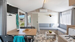 Een gezellige, compacte ruimte met een eethoek, een bank en een kitchenette.